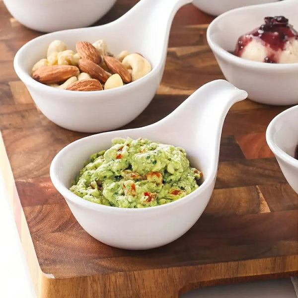 White ceramic bowls with various contents on a wooden surface