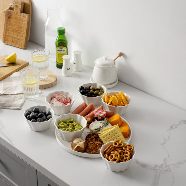 Assorted snacks on a white marble countertop with a bottle of Moët & Chandon in the background.