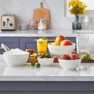 Kitchen counter with bowls of fruit and a drink, featuring a modern kitchen setting.