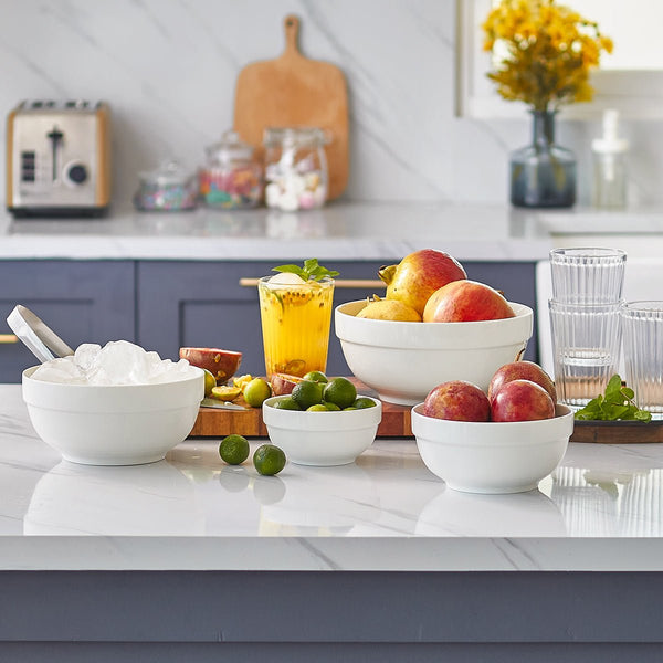 Kitchen counter with bowls of fruit and a drink, featuring a modern kitchen setting.