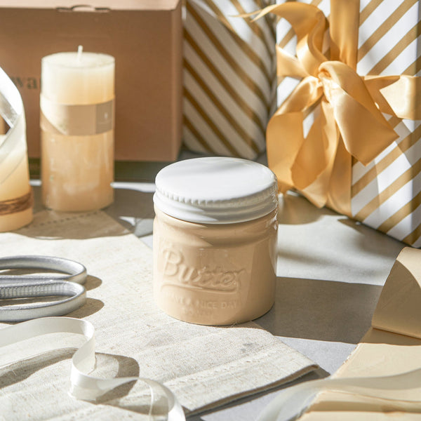 Butter jar on a table with decorative items in the background
