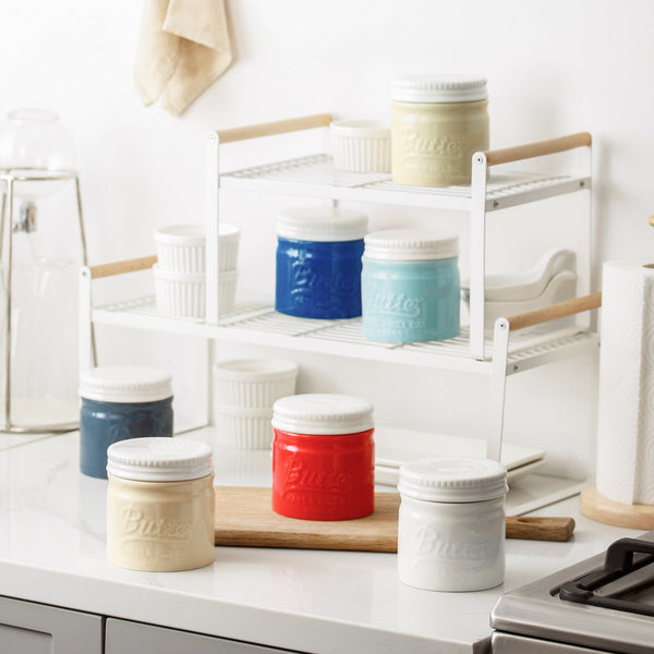 Colorful canisters on a kitchen shelf with a white background