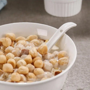 Bowl of porridge with a spoon on a textured surface