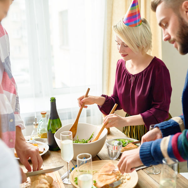 People preparing food together at a table with a festive atmosphere