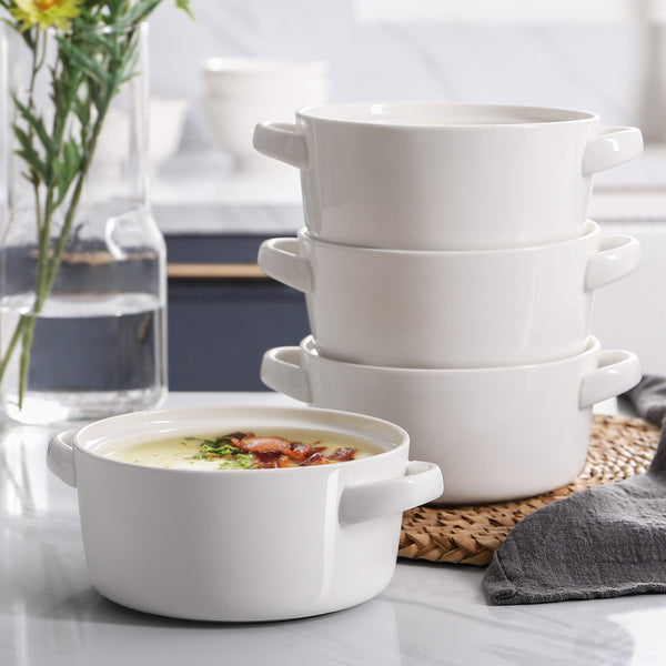 Stack of white ceramic bowls on a table with a blurred kitchen background