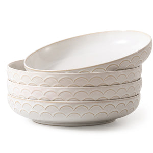 Set of four stoneware pasta bowls with wave pattern on a white background
