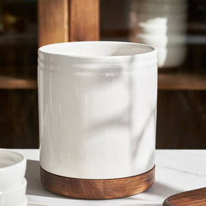 White ceramic kitchen organizer with wooden base on a table