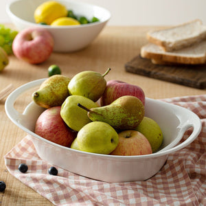 White bowl with pears and apples on a checkered cloth