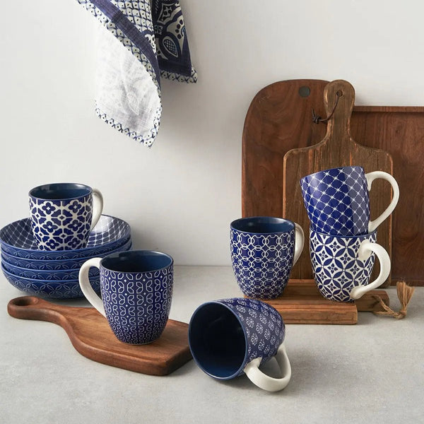 Set of blue and white patterned mugs on wooden trays with a neutral background