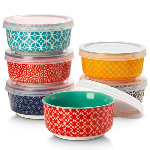 Set of six colorful patterned bowls with lids on a white background
