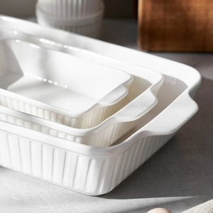 Set of white ceramic baking dishes on a gray surface