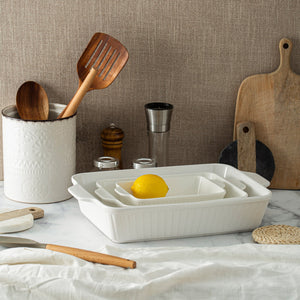 Kitchen utensils and appliances on a countertop with a neutral background