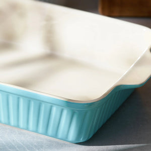 Rectangular baking dish with turquoise bottom and white top on a gray surface