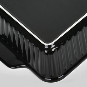 Close-up of a black rectangular object with ribbed texture on a light gray background