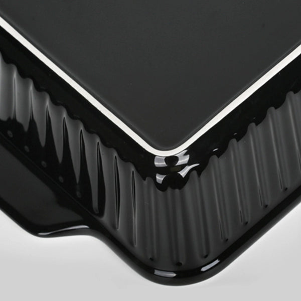 Close-up of a black rectangular object with ribbed texture on a light gray background