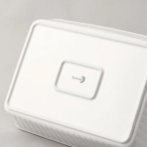 White ceramic baking dish with a lid on a gray background