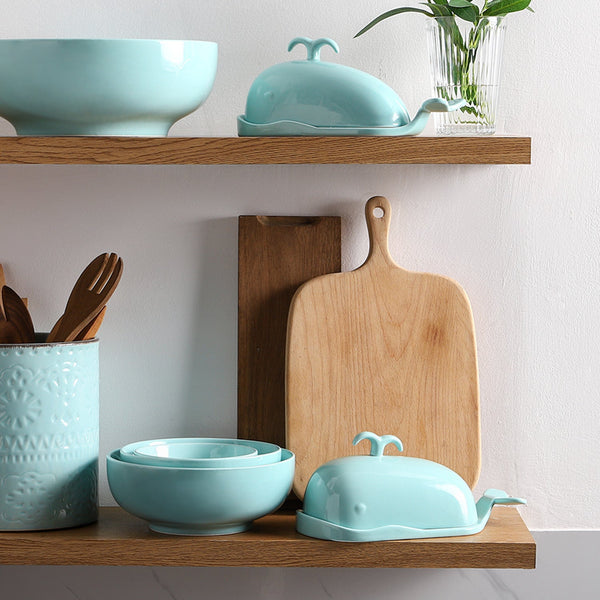 Kitchen shelves with turquoise bowls and a wooden cutting board.