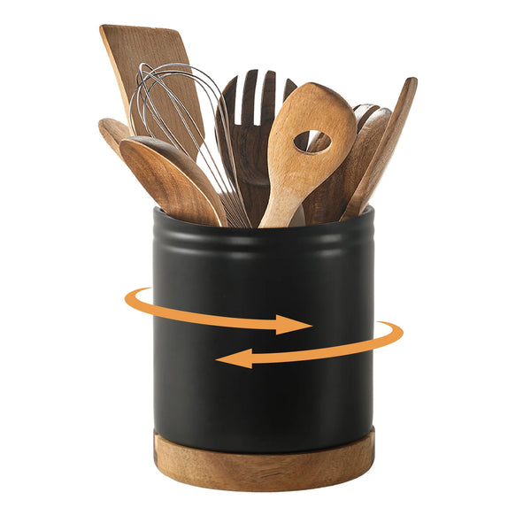 Black holder with wooden utensils and a whisk on a white background