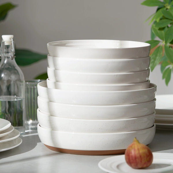 Stack of white ceramic bowls on a table with a blurred background