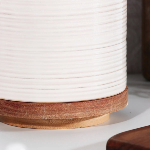 Close-up of a cylindrical object with a white textured top and wooden base.