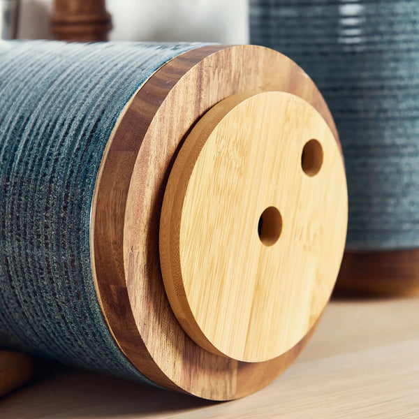 Wooden spool with blue thread on a wooden surface